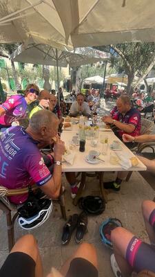 Cyclists sitting around a table in a cafe
