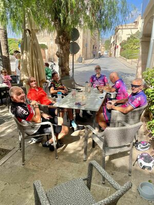 Cyclists sitting around a table in a cafe