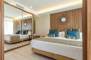 A hotel room with a large bed and large mirrored wardrobe